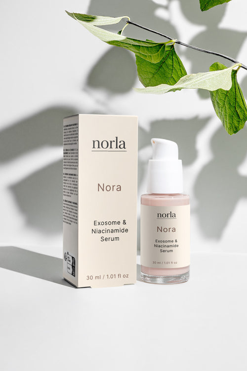 Nora — Exosome & Niacinamide Serum by Norla, box and bottle with a botanical leaf
