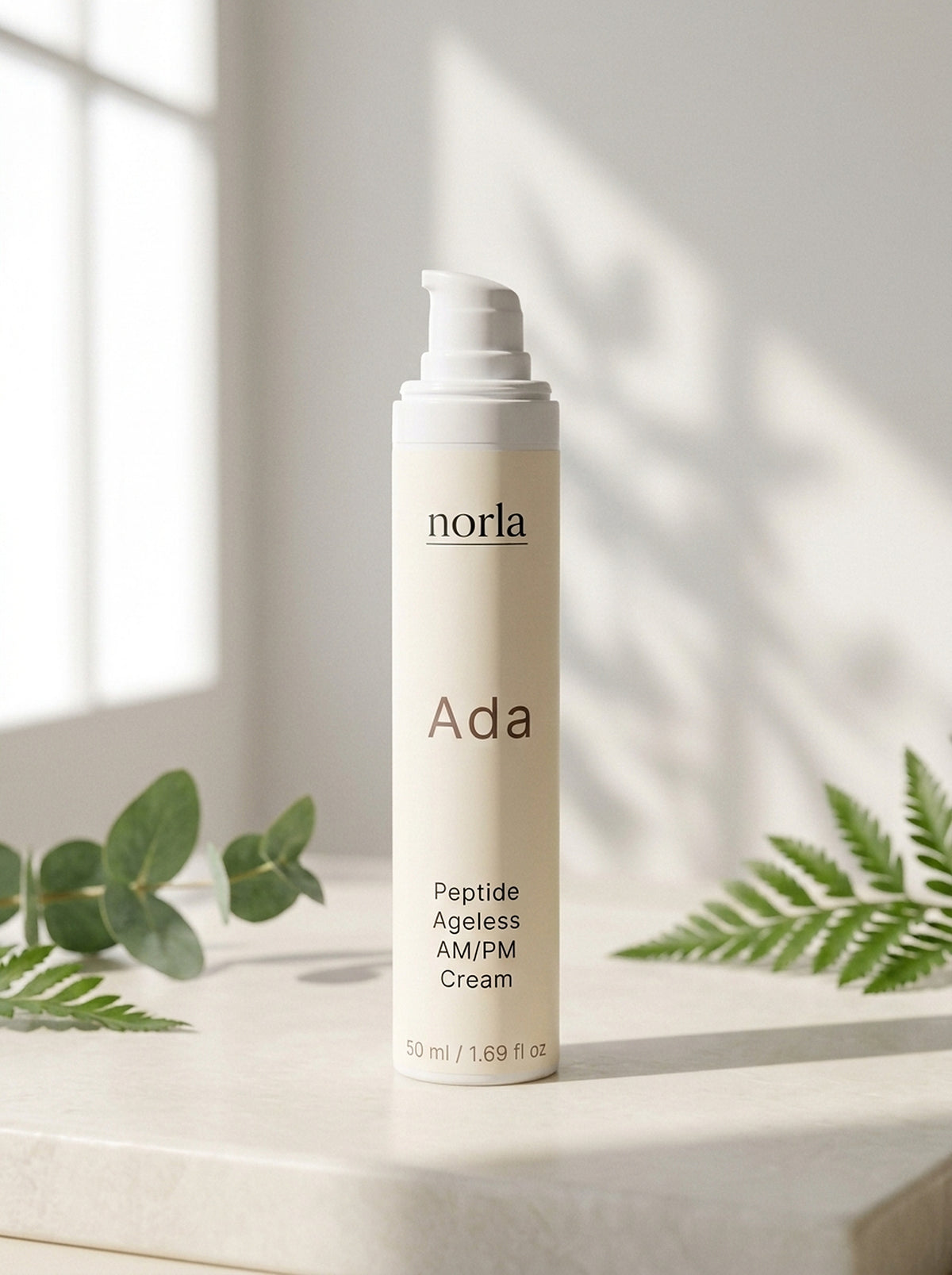 Ada Peptide Ageless AM/PM Cream 50 ml by Norla, airless pump bottle on a marble surface with eucalyptus and fern