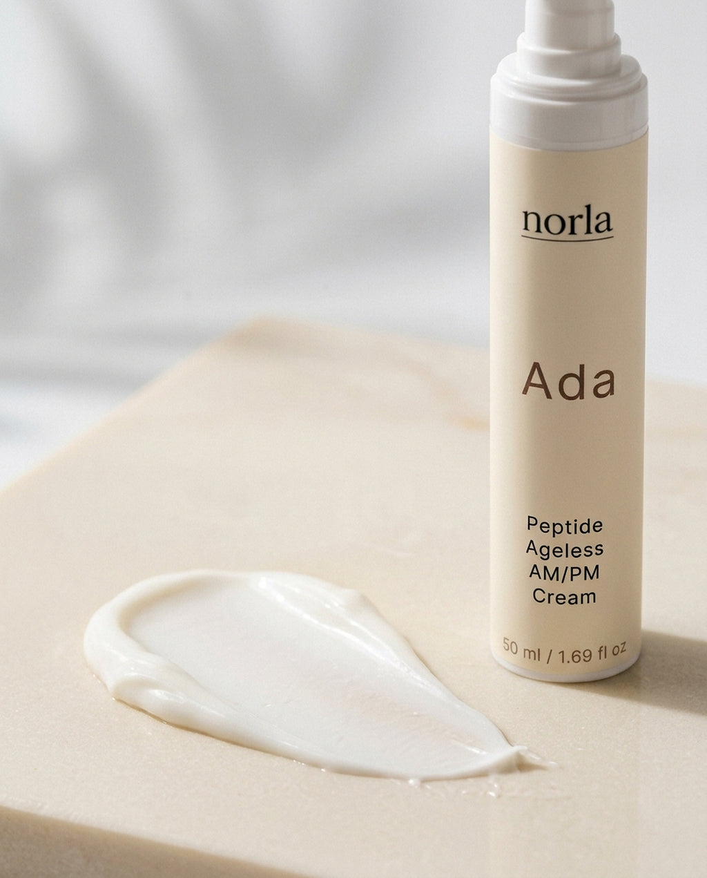 Texture of Ada Peptide Ageless AM/PM Cream by Norla: a rich white cream smear next to the bottle