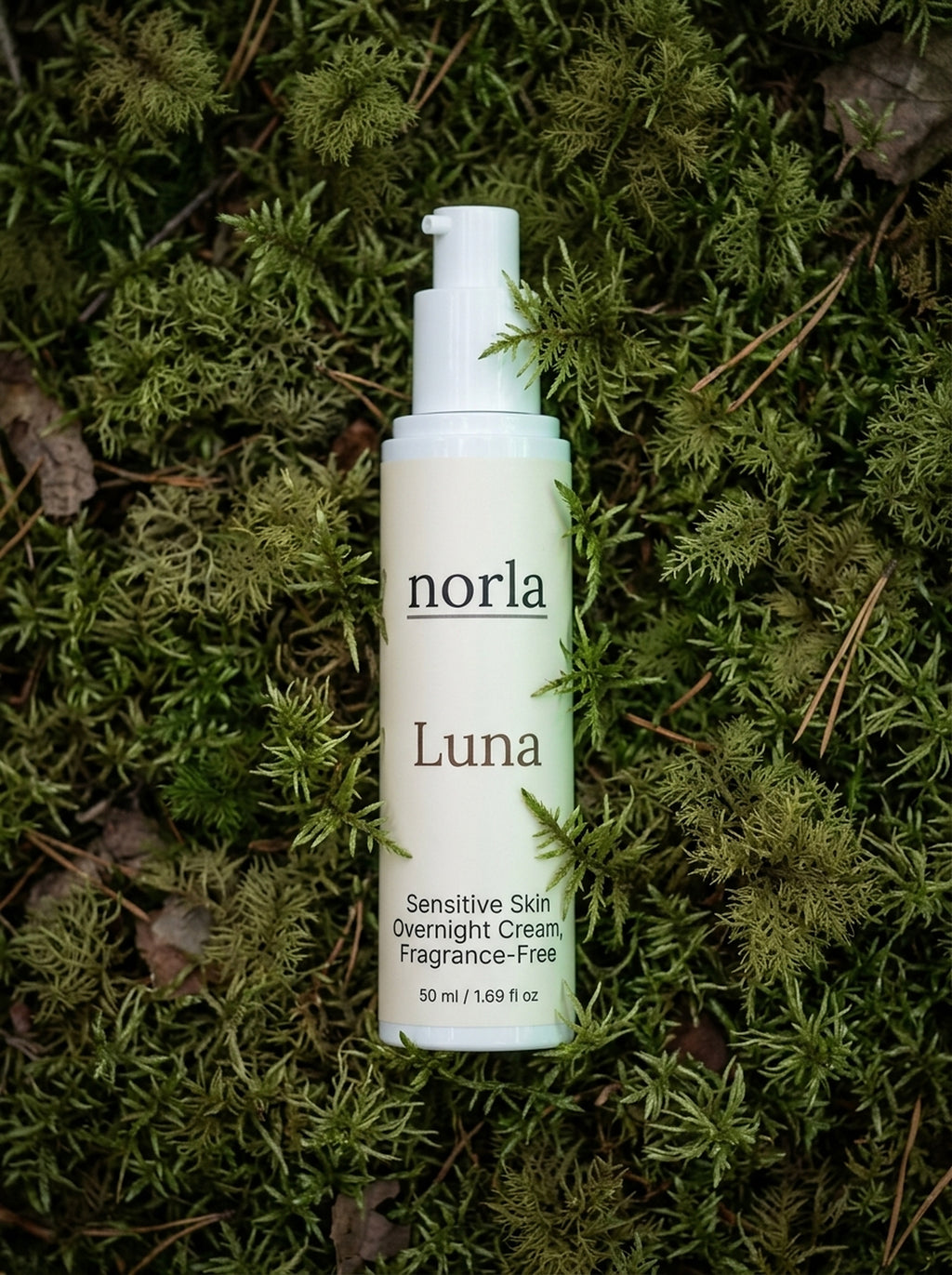 Luna Sensitive Skin Overnight Cream 50 ml by Norla, fragrance-free airless pump bottle lying on green moss