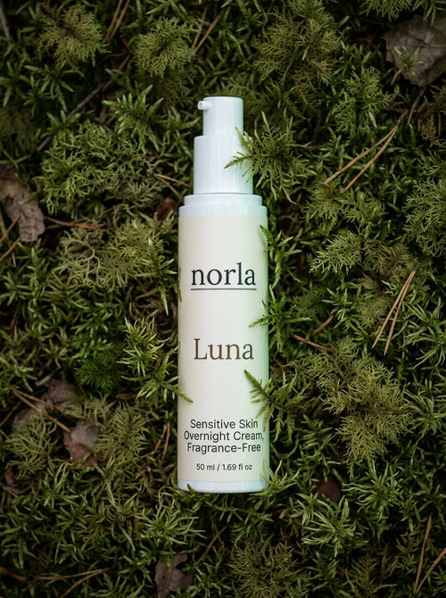 Luna Sensitive Skin Overnight Cream 50 ml by Norla, fragrance-free airless pump bottle lying on green moss